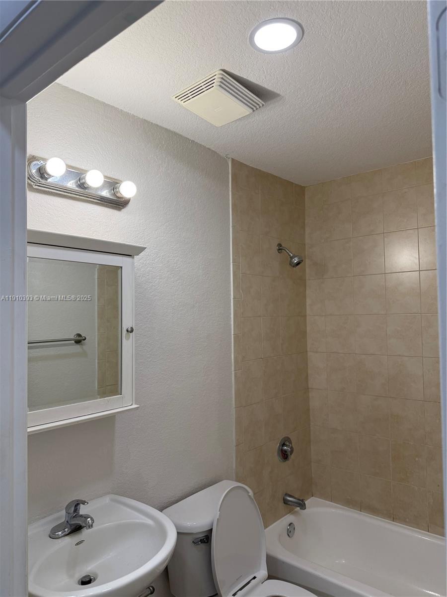7612 Northwest 38th Court, Unit 13 Davie, FL 33024 - Photo 7 of 10 a bathroom with a sink a toilet and shower