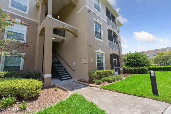 a view of an empty room with a chandelier fan