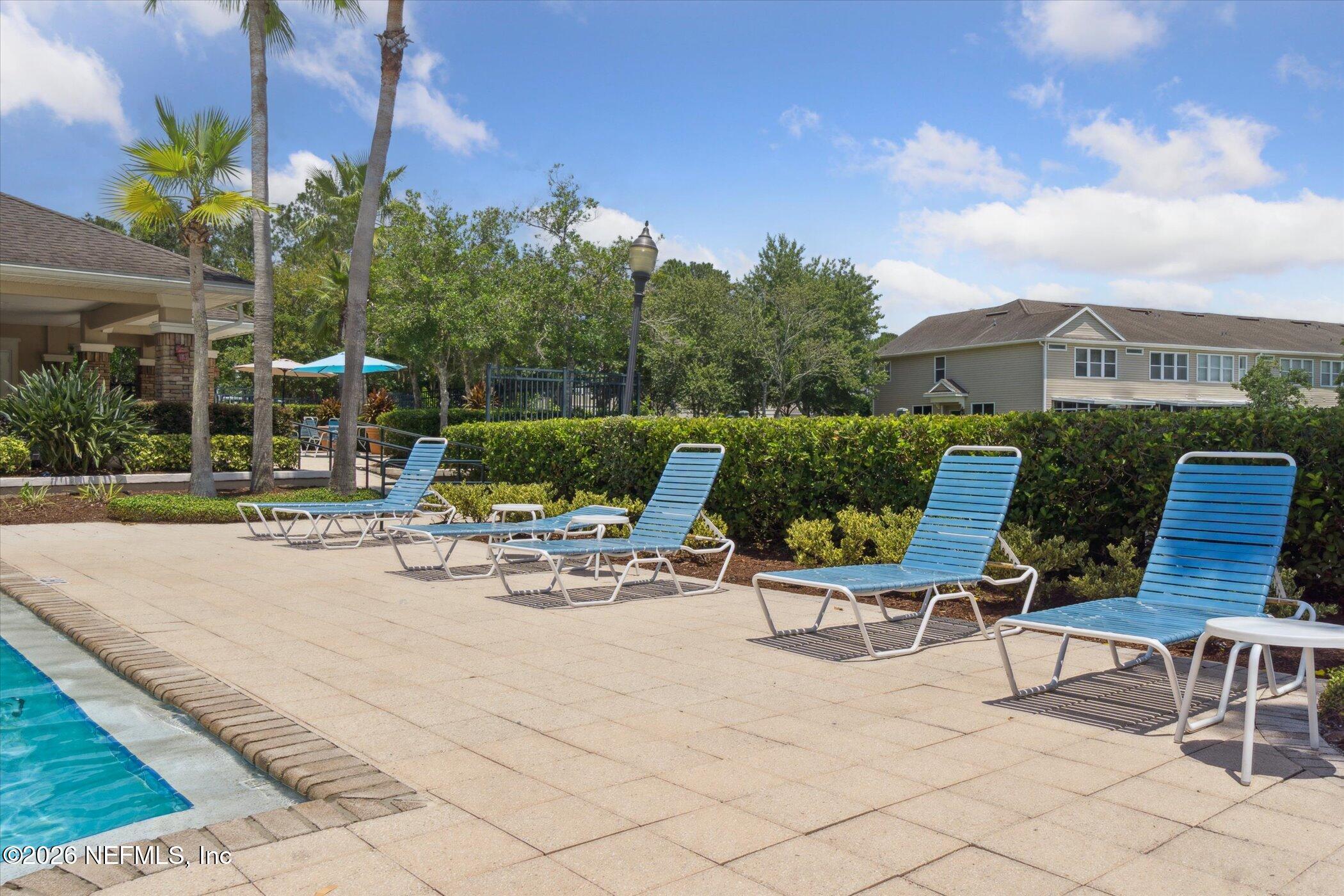 7990 Baymeadows Road, Unit 201 Jacksonville, FL 32256 - Photo 38 of 42 a view of a patio with couches and table and chairs with potted plants and big yard