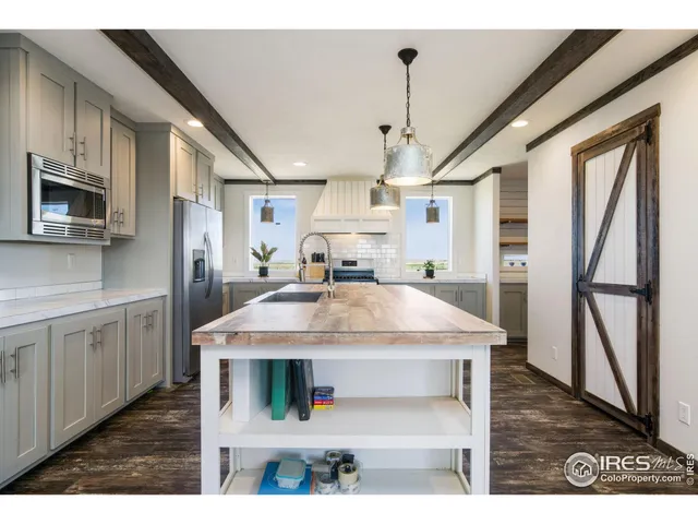 a kitchen with stainless steel appliances granite countertop a sink and a refrigerator