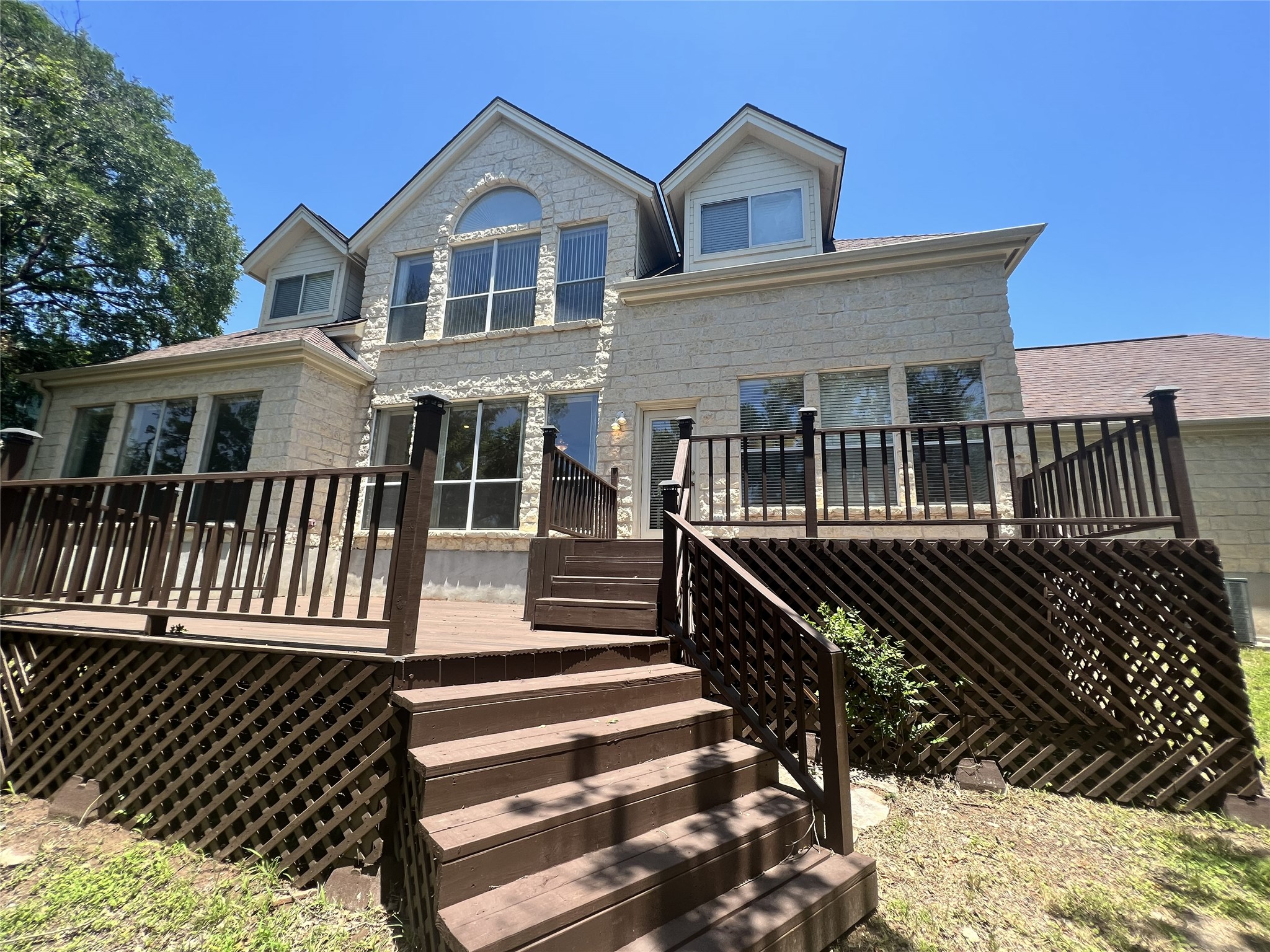 9405 Ashton Ridge Austin, TX 78750 - Photo 22 of 22 A spacious outdoor wooden deck extends from the charming stone-clad home.