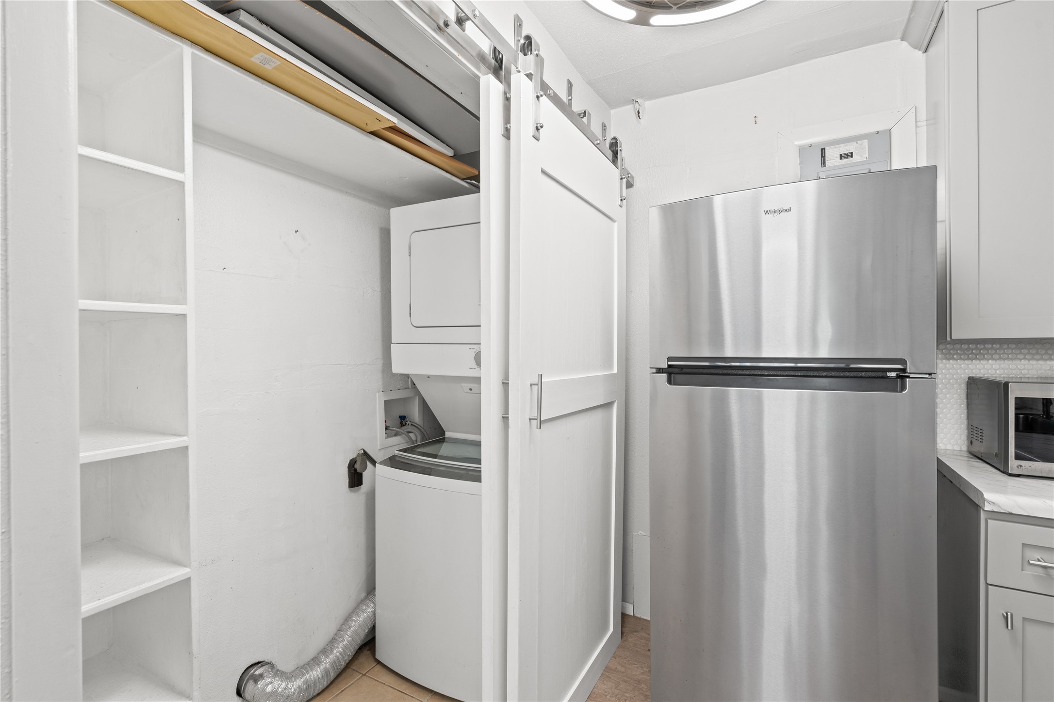 3924 West Alabama Street, Unit 4 Houston, TX 77027 - Photo 17 of 21 The refrigerator conveys with the home. To the left, hidden behind a barn door, you'll find pantry space and a stackable washer and dryer that also remain with the home.