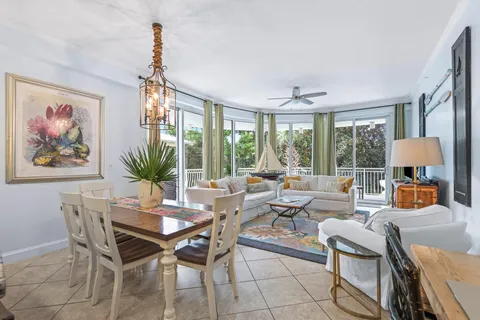 a kitchen with stainless steel appliances a dining table chairs and refrigerator