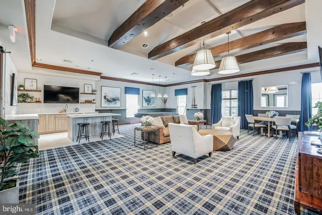 a living room with furniture a flat screen tv and kitchen view