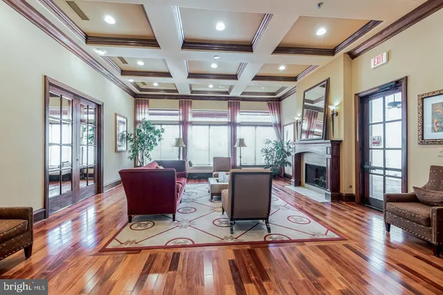 a living room with furniture a flat screen tv and wooden floor