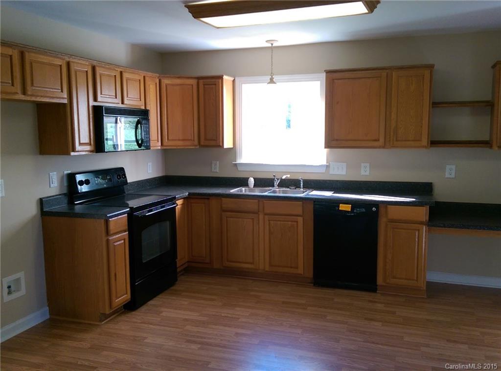 162 Sardis Road Mooresville, NC 28115 - Photo 3 of 15 a kitchen with granite countertop wooden cabinets stove and sink