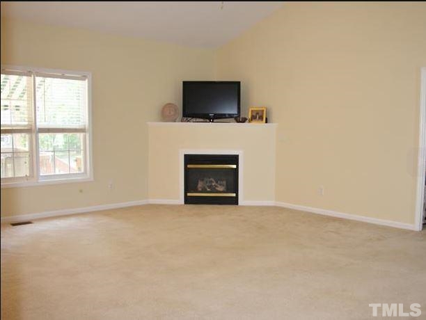 125 Oak Road Butner, NC 27509 - Photo 7 of 8 Living room with corner fireplace and view of back deck and yard.