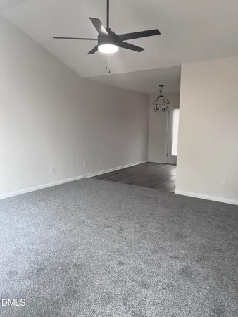 an empty room with a ceiling fan and a window