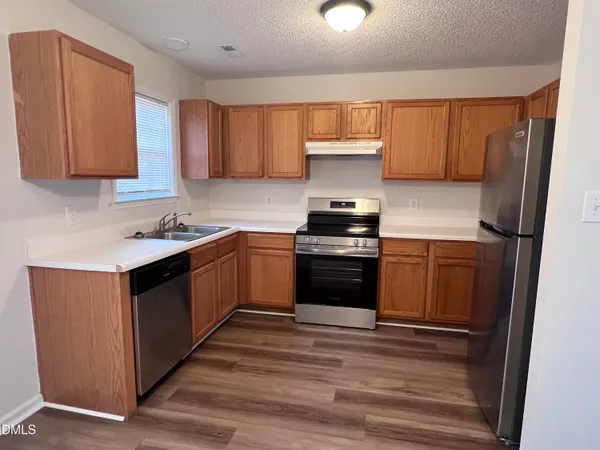 a kitchen with stainless steel appliances a stove a sink and a refrigerator