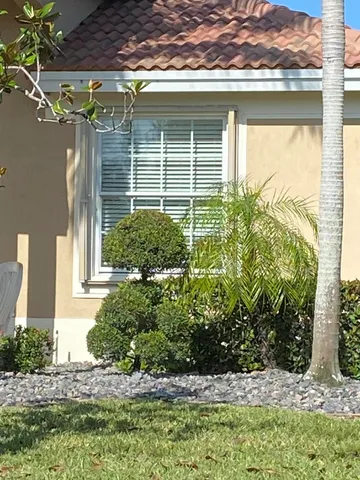 a front view of a house with a yard and potted plants