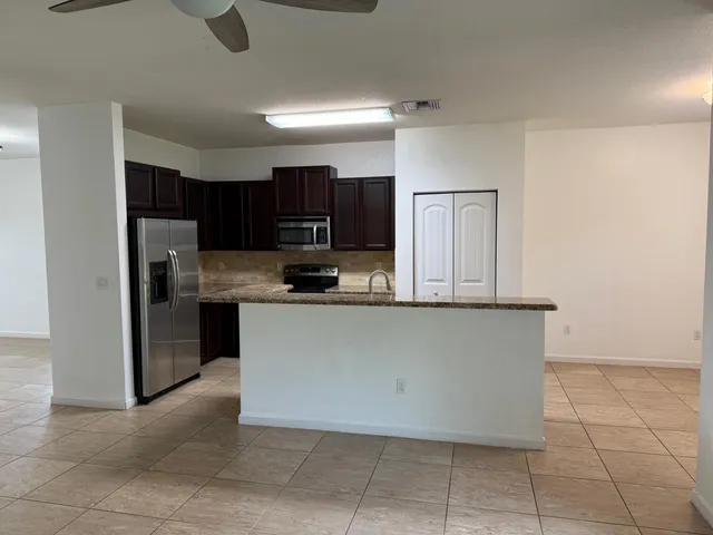 a kitchen with stainless steel appliances granite countertop a refrigerator and a stove
