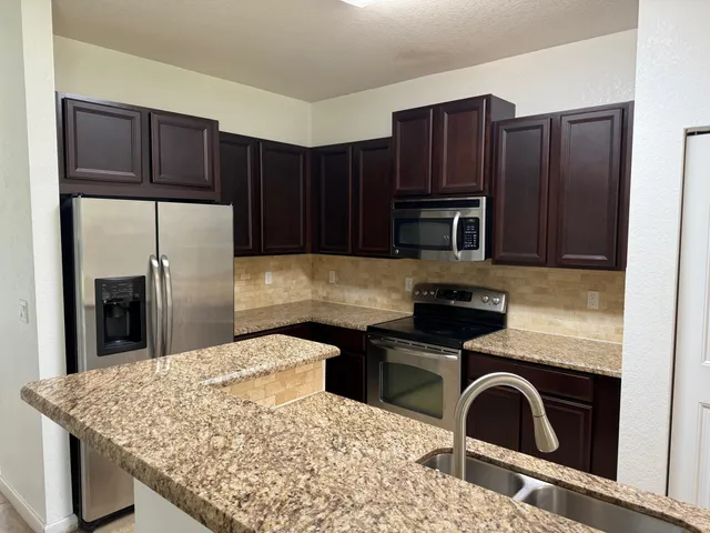 a kitchen with stainless steel appliances wooden cabinets and granite counter tops