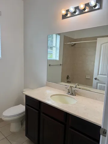 a bathroom with a sink a toilet a mirror and vanity
