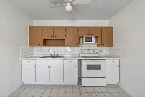 a kitchen with white cabinets stainless steel appliances and sink