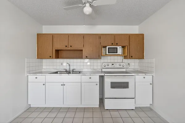 a kitchen with white cabinets stainless steel appliances and sink