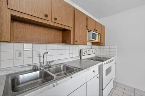a view of an empty room with window and cabinet