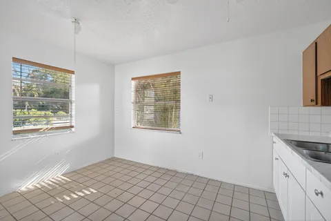 a view of empty room with window and chandelier fan