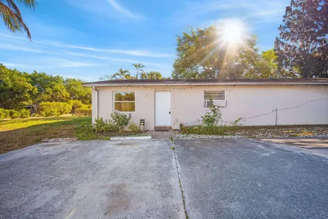 a view of a house with backyard and tree