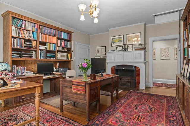 a bedroom with two beds and a dresser next to a window