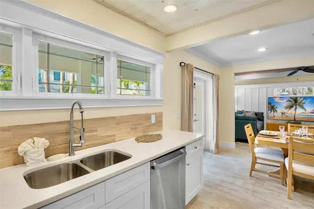 a kitchen with a sink and chairs