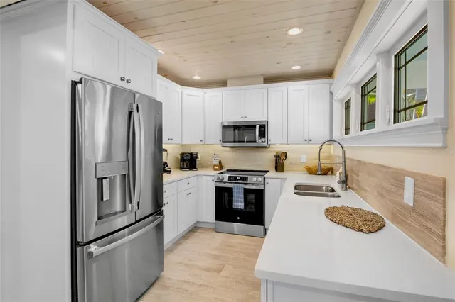 a kitchen with stainless steel appliances a refrigerator stove microwave and sink
