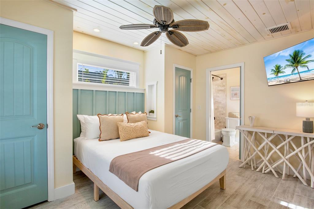 709 Fern Street Anna Maria, FL 34216 - Photo 21 of 35 a bedroom with a bed and a chandelier