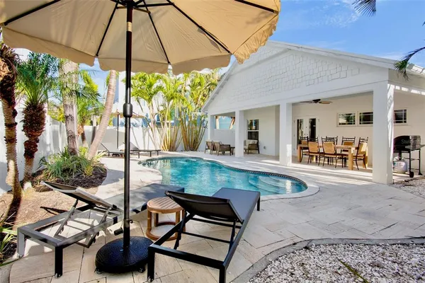 a view of a backyard with table and chairs under an umbrella