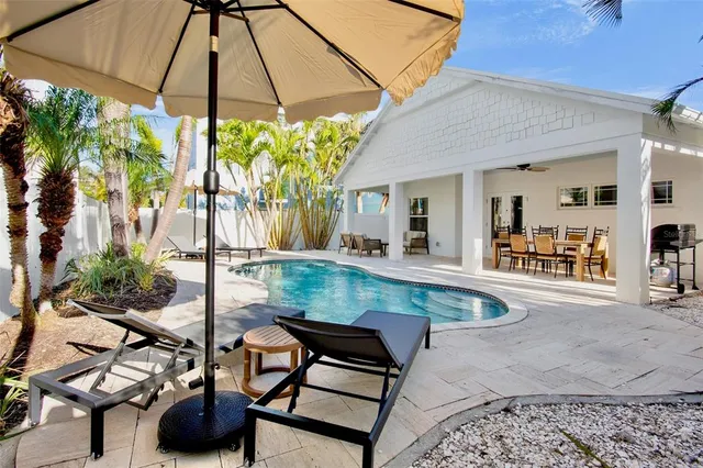 a view of a backyard with table and chairs under an umbrella