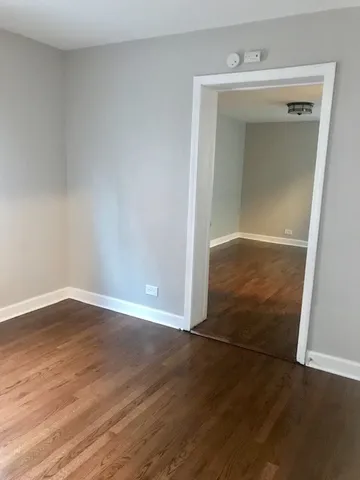 an empty room with wooden floor and closet