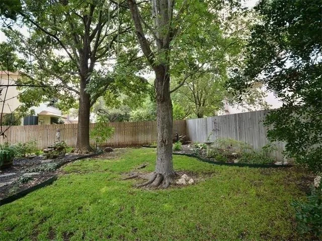 a view of a backyard with large trees