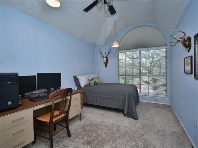 7508 Windrush Drive Austin, TX 78729 - Photo 14 of 22 a bedroom with a bed and a desk