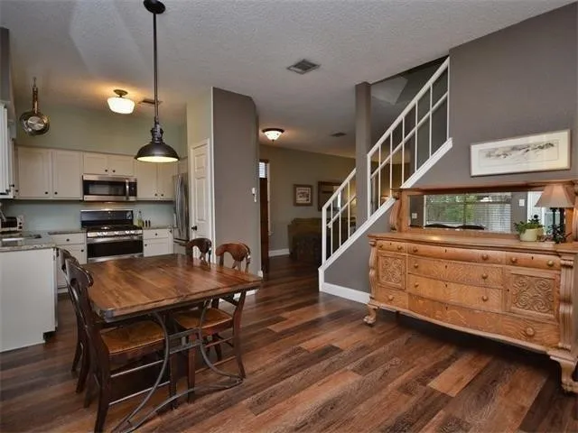 a kitchen with stainless steel appliances granite countertop a stove a sink and a refrigerator