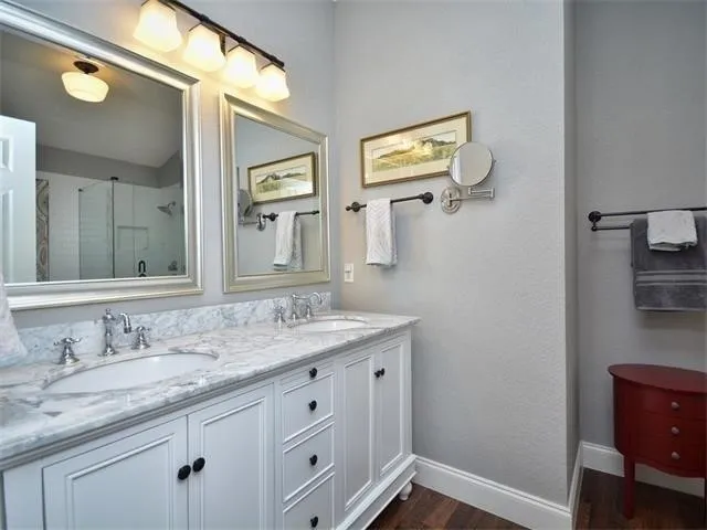 a bathroom with a granite countertop sink and a mirror