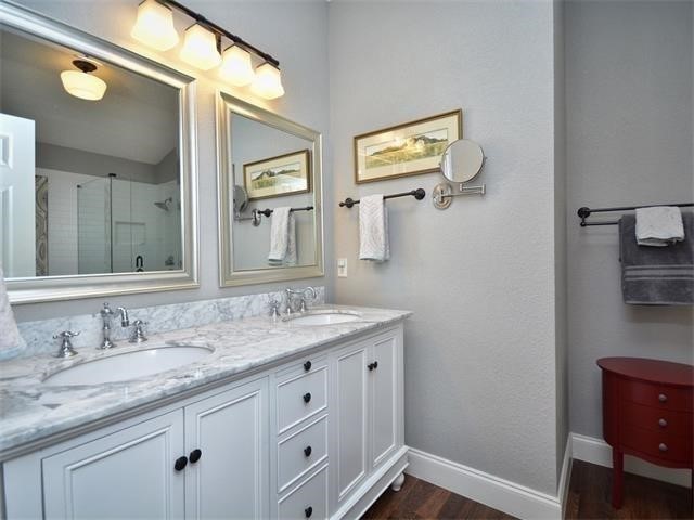 7508 Windrush Drive Austin, TX 78729 - Photo 19 of 22 a bathroom with a granite countertop sink and a mirror