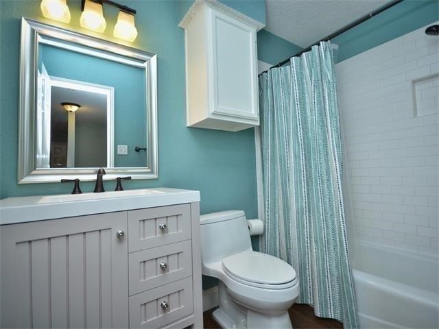 7508 Windrush Drive Austin, TX 78729 - Photo 21 of 22 a bathroom with a toilet a sink and a mirror