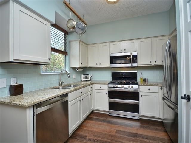 7508 Windrush Drive Austin, TX 78729 - Photo 8 of 22 a kitchen with stainless steel appliances granite countertop a sink and a stove