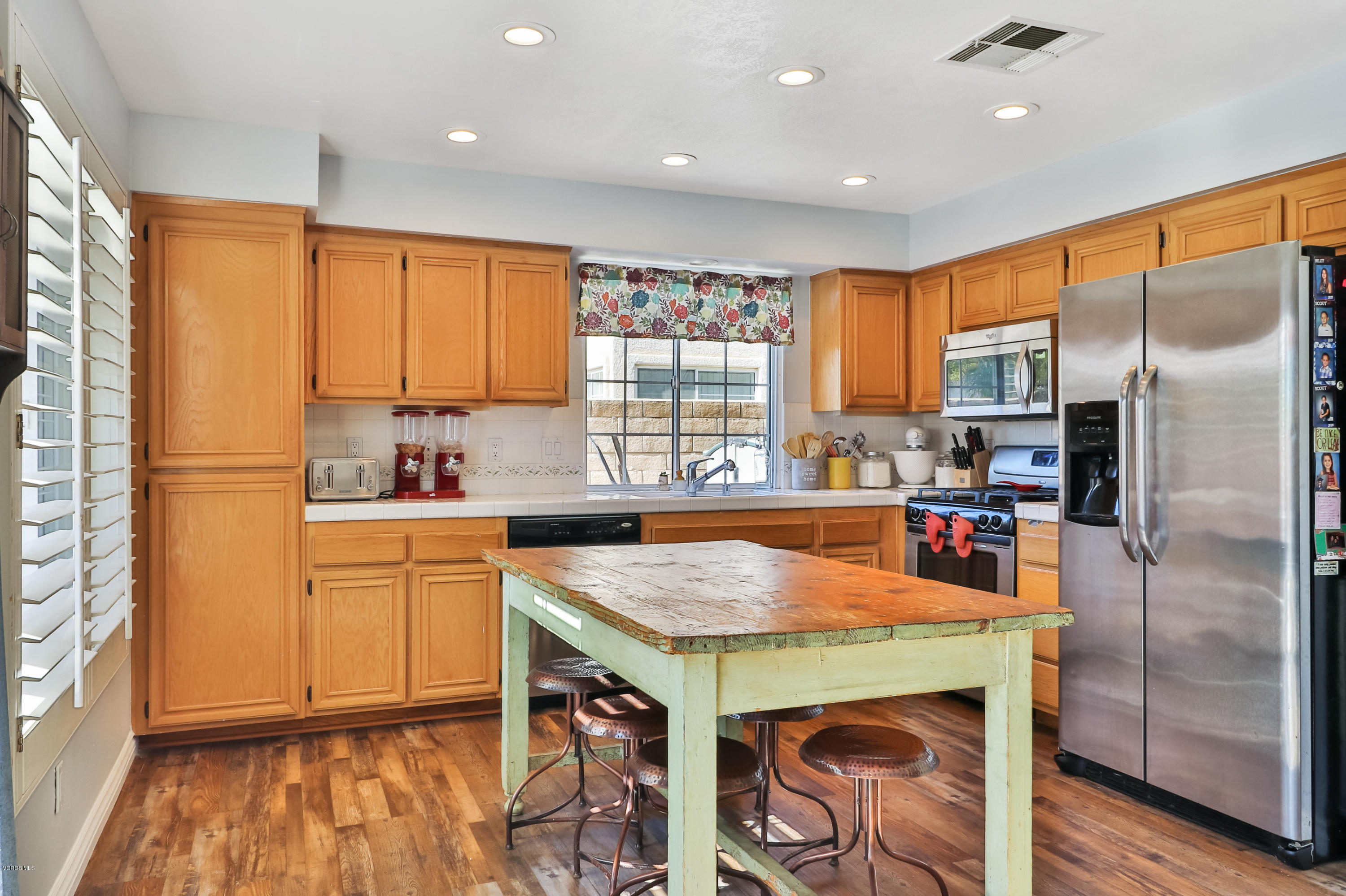 1729 Empty Saddle Road Simi Valley, CA 93063 - Photo 8 of 28 a kitchen with stainless steel appliances granite countertop a refrigerator a sink dishwasher and a stove with wooden floor