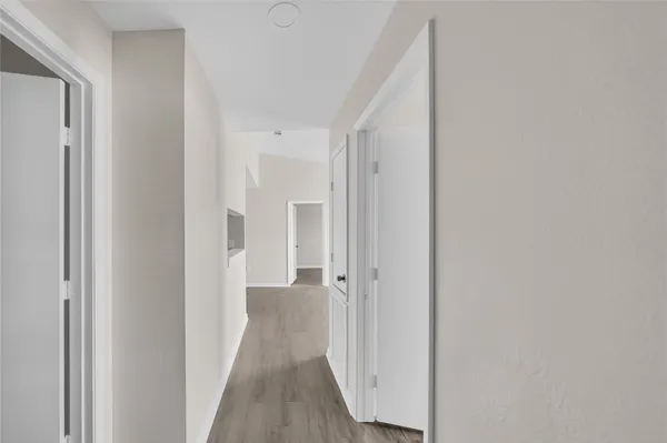 a view of a hallway with wooden floor