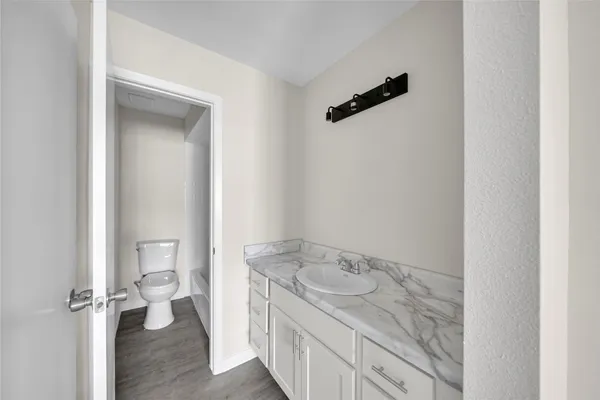 view of a bathroom with a granite countertop sink