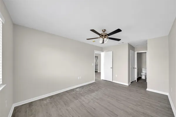 a view of a big room with wooden floor and a ceiling fan