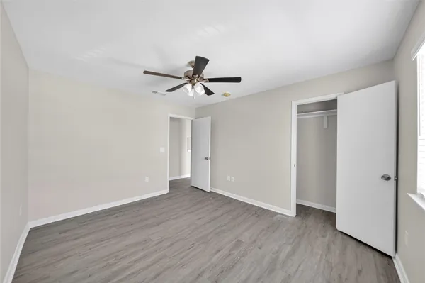 a view of a big room with wooden floor and a ceiling fan