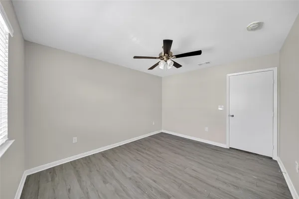 a view of a room with wooden floor and a window