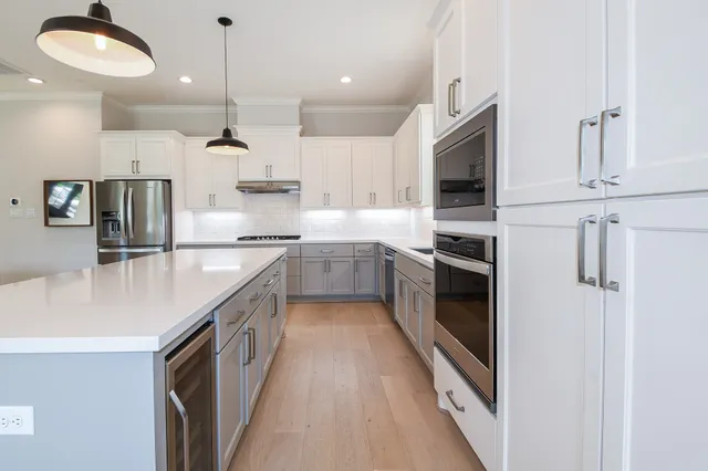 a kitchen with stainless steel appliances granite countertop a sink a stove and a refrigerator