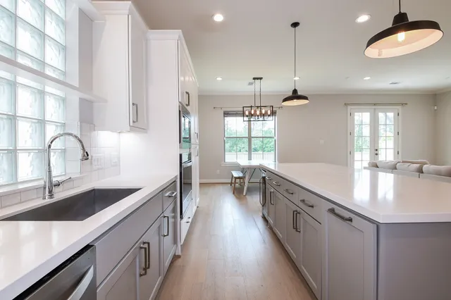a large kitchen with kitchen island a large counter space a sink appliances and a counter top space