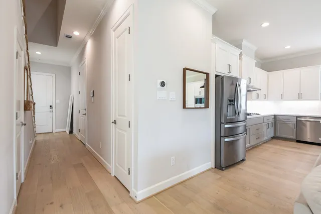a view of a kitchen with refrigerator and white cabinets