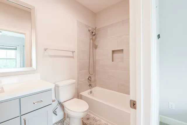 a bathroom with a granite countertop toilet a sink and a bathtub