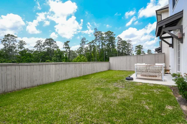 a view of a back yard with a bench and wooden fence