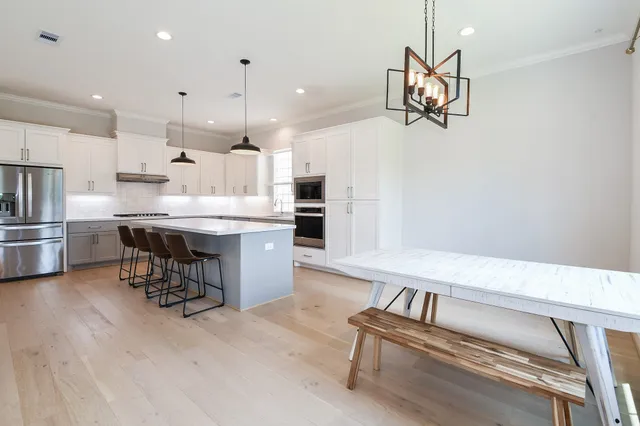 a kitchen with kitchen island white cabinets and stainless steel appliances