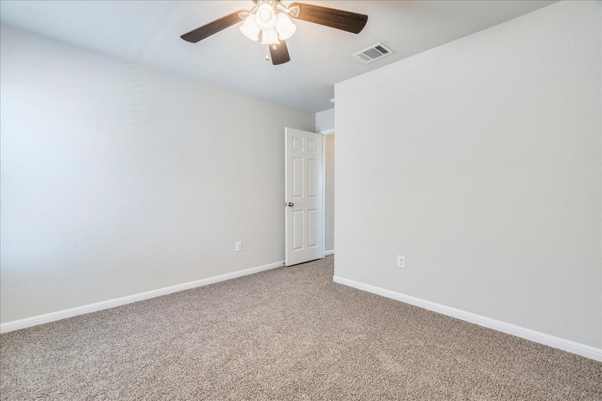 312 Triumph Road Buda, TX 78610 - Photo 29 of 36 an empty room with a chandelier fan
