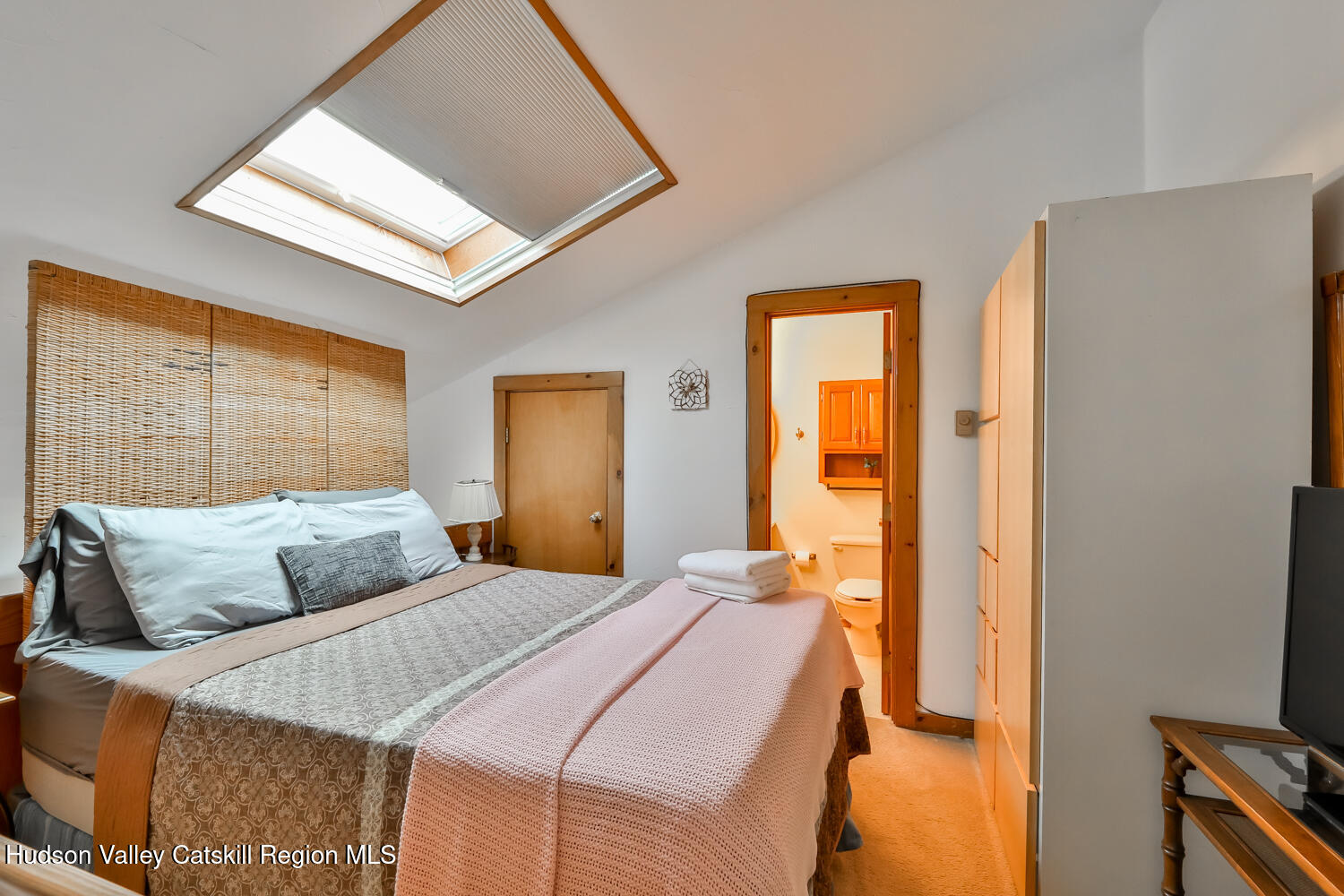 7675 Main Street, Unit B14 Hunter, NY 12442 - Photo 14 of 18 a bedroom with a bed and a flat tv screen next to a window